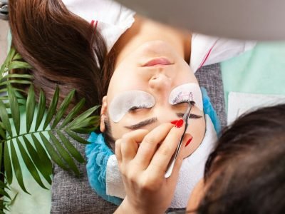 Eyelash extensions in a beauty salon. A young girl lies on a couch